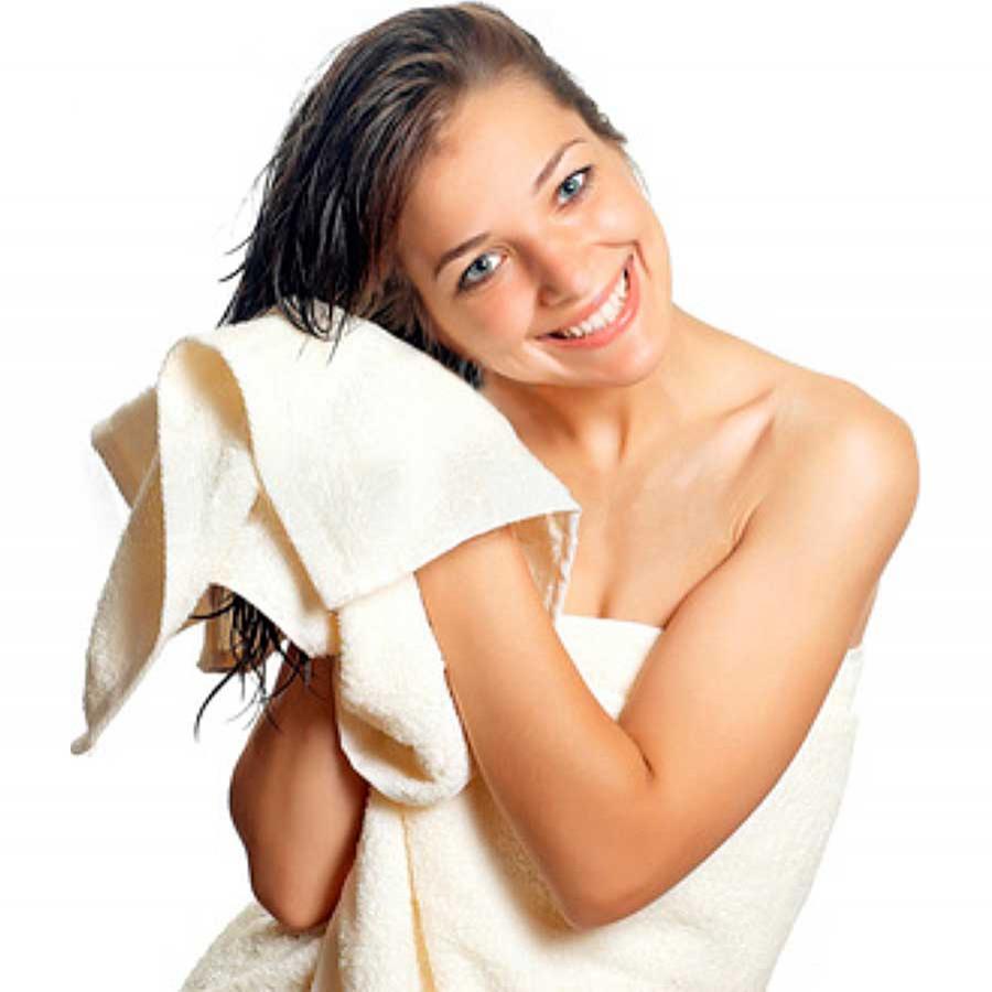 Woman drying hair with white towel. Water Ways Baja purification systems make your whites whiter.